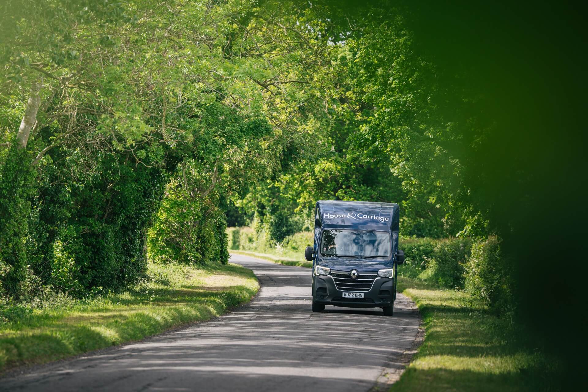 The House and Carriage removals van driving down a costwolds road in the summer